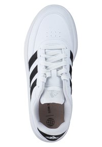 White sneaker with black stripes, made of synthetic material. Features round toe, lace-up closure, and perforated accents on top.