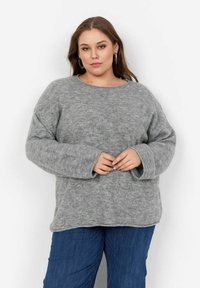 Maglione grigio chiaro, oversize, realizzato in tessuto morbido. Presenta un collo tondo e maniche lunghe, con una vestibilità ampia e dettagli minimi di elasticità.