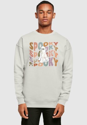 Svetlo sivá mikina so grafikou ducha obklopenou slovom "SPOOKY" v rôznych farbách a s opotrebovanými textúrami. Voľný strih s rebrovanými manžetami.