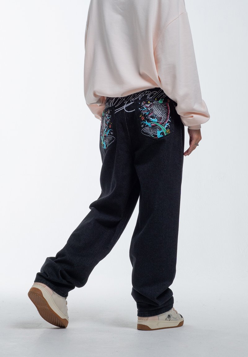 Jeans de mezclilla oscura holgados con vibrantes diseños bordados en los bolsillos traseros, con una pierna ligeramente ajustada y cintura a media altura.