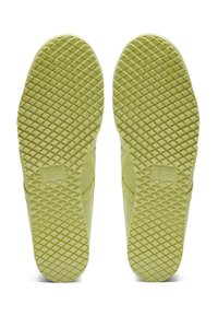 Vihreänkeltaiset tennarien pohjat esittävät käytössä olevaa timantin muotoista pintakuviointia, jossa on integroitu "Onitsuka Tiger" -logo kumipinnalle.