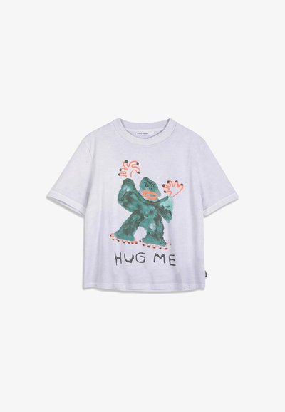 T-shirt blanc à manches courtes avec un gorille cartoon vert et des mains orange, avec le texte "HUG ME" sous l'illustration.