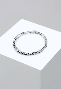 Silver bracelet featuring a woven design with a lobster clasp, smooth texture, and a modern finish. Accented with a small logo on the clasp.