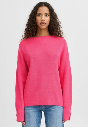 Jasnoróżowy, oversize'owy sweter z dzianiny z szerokim dekoltem i prążkowanym wzorem. Długie rękawy z prążkowanymi mankietami. W połączeniu z dżinsami.
