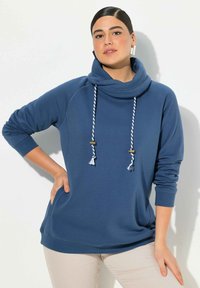 Felpa blu con collo a cowl, dotata di cordini bianchi e blu con pon pon, polsini a costine e vestibilità comoda.