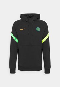 Un sweat à capuche noir avec une poche kangourou, présentant des accents verts et orange, un logo circulaire et des poignets élastiques. Fabriqué en tissu doux.