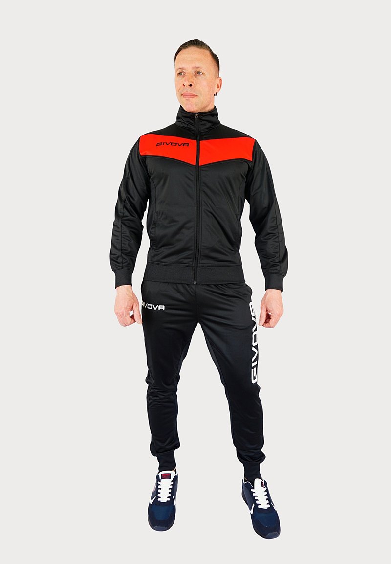 Zwart trainingspak met een rode streep op de borst, bestaande uit een ritsjack en broeken met elastische tailleband. Accentuert met het "GIVOVA" logo in het wit.