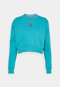 Turkos kort ärmad sweatshirt tillverkad av mjukt tyg. Har en ribbad halsringning och ärmslut, med en liten broderad logo på bröstet.