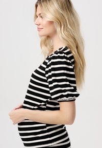 Stribet graviditetsbluse med sorte og hvide vandrette striber, korte puffærmer og en blød ribbet tekstur. Designet til at imødekomme en voksende mave.