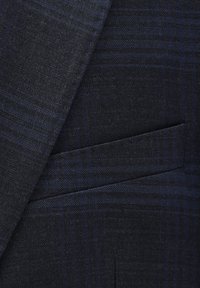 Marineblauer Anzugstoff mit einem dezenten Karomuster, glatter Textur und einer einzelnen Tickettasche auf der rechten Seite.