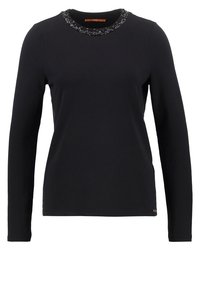 Černé tričko s dlouhým rukávem z měkké látky s kulatým výstřihem zdobeným korálkovými ozdobami. Na lemu je malá logo.