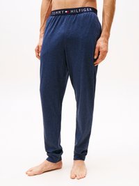 Pantaloni de pijama bleu marin cu o talie elastică, având logo-ul "TOMMY HILFIGER". Tesătură moale, design cu picior tapered, cu mansete la glezne.