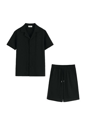 Chemise noire à manches courtes avec boutons, associée à un short noir à taille élastique avec cordons de serrage et poches latérales.