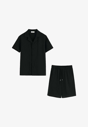 Chemise noire à manches courtes avec boutons, associée à un short noir à taille élastique avec cordons de serrage et poches latérales.