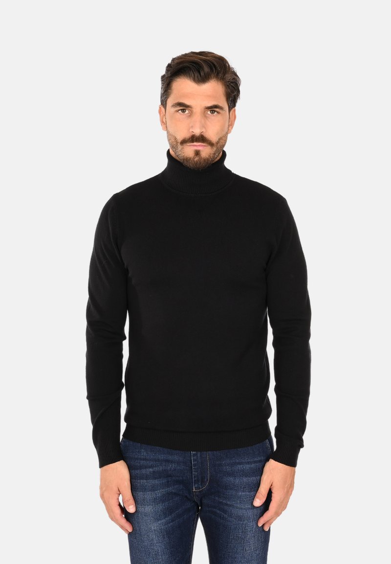 Maglione a collo alto nero realizzato in un tessuto a maglia liscia, con maniche lunghe e una silhouette aderente, abbinato a jeans blu.