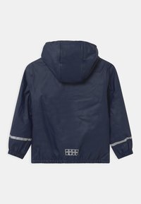 Navy waterproof jacket with a hood, elastic cuffs, and reflective band accents. Smooth texture and casual design, with a cinched hem.
