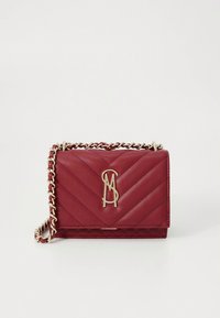 Κόκκινη τσάντα από δερματίνη με ανάγλυφο μοτίβο chevron, λουρί αλυσίδα σε χρυσή απόχρωση και διακοσμητικό με λογότυπο. Συμπαγής ορθογώνιο σχήμα και λεία υφή.