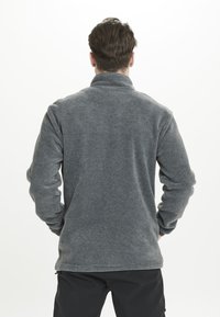 Pullover in pile grigio con colletto alto e maniche lunghe, caratterizzato da una texture liscia e un taglio morbido, ideale per essere indossato a strati.