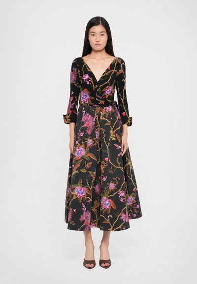 Schwarzes Blumenwickelkleid mit langen Ärmeln, das lebendige rosa und lila Blumen auf einem strukturierten Stoff zeigt, abgeschlossen mit einem Bindegürtel in der Taille.