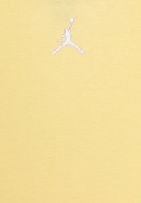 Žluté bavlněné tričko s bílým vyšívaným logem Jumpman na hrudi. Hladký povrch s klasickým designem kulatého výstřihu.