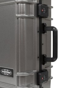 Gray hard-shell suitcase with a textured finish, featuring a black handle and combination lock. Eastpak logo located on the side.
