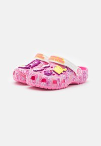 Růžové plastové dřeváky s barevnými motivy postaviček, bílé popruhy se textem "HELLO KITTY A PŘÁTELÉ" a texturované podrážky.