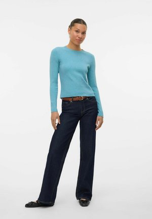 Ljusblå ribbad långärmad topp tillsammans med mörkblå vida jeans, fullbordad med ett brunt bälte och svarta ballerina skor.