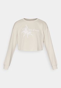 Beige kort sweatshirt med långa ärmar, prydd med en vit grafik av en sol och texten "State of mind" tryckt på framsidan.