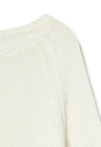 Close-up of a white knitted sweater showing the round neckline and textured stitch pattern.