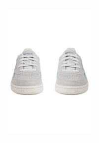 Sneakers bianchi in suede con dettagli perforati, lacci piatti e un accento logo azzurro. Punta rotonda e suola in gomma. Design classico.