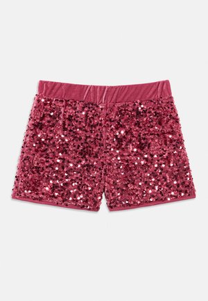 Rozā samta šorti pilnībā noklāti ar spīdīgām sequins un elastīgu jostasvietu, nolikti uz balta fona.