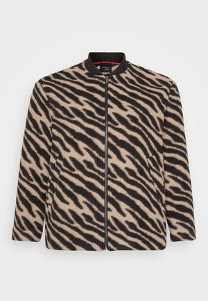 Giacca con zip a maniche lunghe beige e nera con stampa zebra, dotata di colletto a coste e tasche laterali, esposta su uno sfondo bianco.