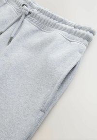 Lichtgrijze sweatpants van zachte stof, met een elastische tailleband met trekkoord, zijzakken en een relaxte pasvorm.