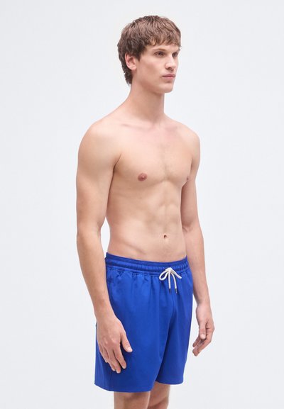 Μπλε μαγιό σορτς κατασκευασμένο από ελαφρύ ύφασμα, με ελαστική ζώνη μέσης και κορδόνι, πλαϊνές τσέπες και μήκος έως τη μέση του μηρού.