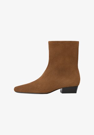 Hnědé semišové kotníkové boty s nízkým černým blokovým podpatkem a špičatou špičkou, zobrazené z vnější strany na bílém pozadí.