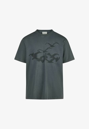 Dunkelgrünes Baumwoll-T-Shirt mit kurzen Ärmeln, das eine Silhouette von fliegenden Vögeln in einem dunkleren Farbton zeigt. Runder Halsausschnitt, lockerer Schnitt.