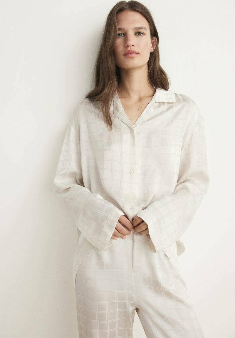 Lichtbeige zijde pyjama set met een knoopsluiting shirt met kraag en subtiel vierkant patroon, gecombineerd met losse broek en ruime mouwen.
