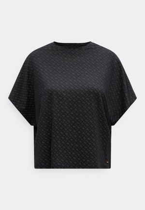 Haut noir oversize à manches courtes avec un motif monogramme diagonal subtil et un col rond sur fond blanc.