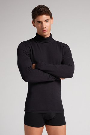 Zwarte lange mouw turtleneck shirt, gemaakt van zachte stof, met een getailleerd ontwerp en een gladde textuur, gecombineerd met zwarte shorts.