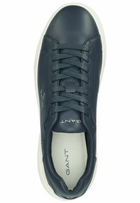 Baskets en cuir bleu marine avec semelle en caoutchouc blanc, bout rond, design à lacets et languette de marque. Texture lisse avec un minimum de détails.