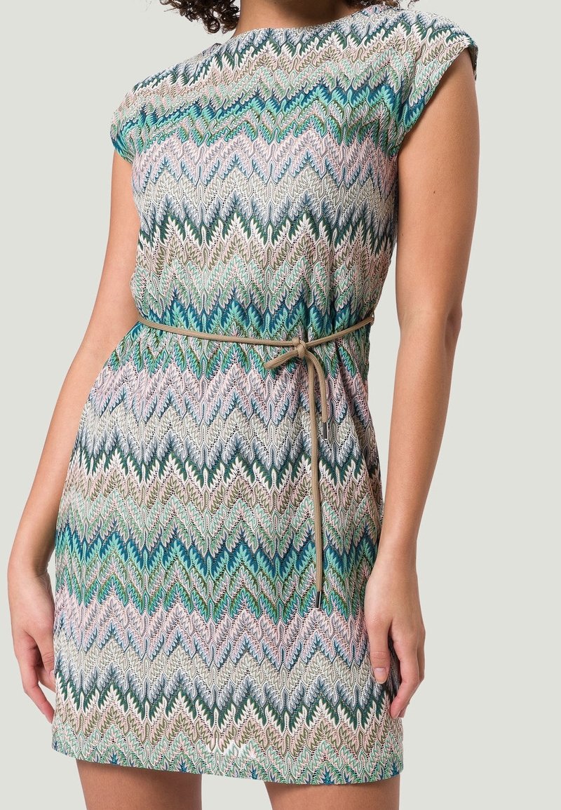 Vestido corto de manga corta, hecho de una tela liviana, con un patrón de zigzag multicolor en turquesa, verde y rosa; ceñido en la cintura.