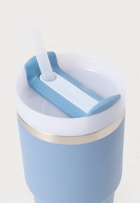 Světle modrý izolační pohár s bílým víčkem a světle modrou brčkem. Disponuje kovovým akcentem a jedinečným designem držáku na brčko.