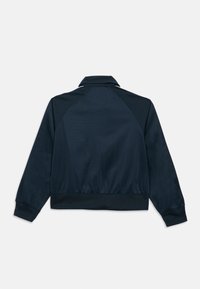 Σκούρο μπλε μπουφάν με γιακά, μανίκια ράγκλαν και ριμπ μανσέτες. Λείο, ελαφρύ ύφασμα με εφαρμοστό ζωνάκι στη μέση.