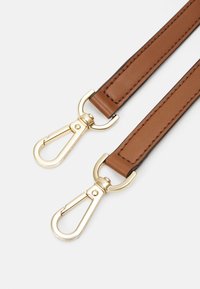 Brunt läderrem med guldtonade detaljer, med två tryckknoppar, platt design och synlig sömnad längs kanterna.