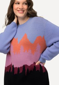 Übergroßer Pullover in Hellblau mit einem farbverlaufenden Bergmuster in Orange, Pink und Schwarz am Saum. Sanfte Stricktextur, runder Ausschnitt.