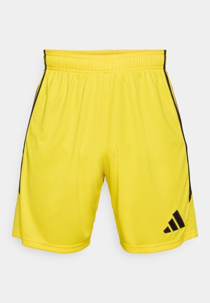 Žute sportske hlačice s elastičnim pojasom, crnim bočnim prugama i logotipom Adidasa na rubu. Izrađene od glatkog, laganog materijala.