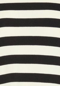 Tessuto a righe bianche e nere con strisce alternate larghe e strette; texture morbida con un design a coste. Nessun elemento hardware o accento notevole.