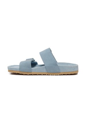 Sandales en suède bleu clair avec deux larges brides, semelle plate et semelle extérieure en caoutchouc texturé, présentant un design simple et des accents neutres.