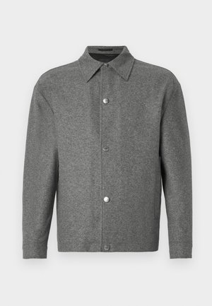 Graue Langarm-Button-Up-Jacke mit spitzem Kragen und metallischen Druckknöpfen an der Vorderseite, auf einem weißen Hintergrund präsentiert.