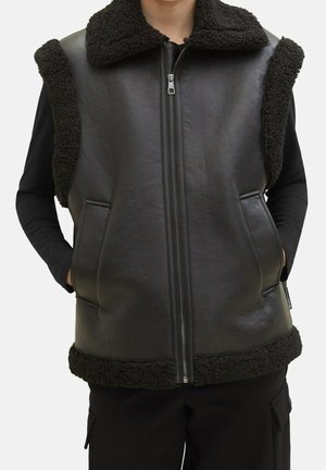 Schwarze Weste aus glattem Leder mit einem strukturierten, dunklen Fleecekragen und Saum. Sie verfügt über zwei seitliche Taschen und einen Reißverschluss vorne.